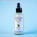 Duma Mbili Coconut Passion Shimmer Body Oil, 4 oz pump bottle on a blue background.